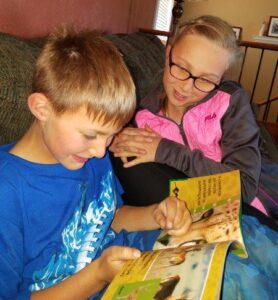 boy reading to sister after effective reading instruction